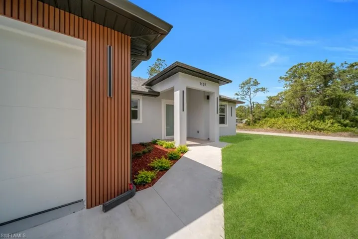 Doorway to property with a lawn