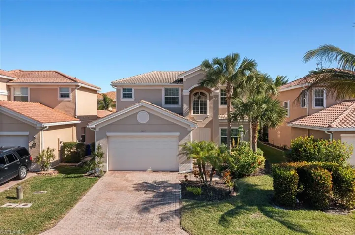 Mediterranean / spanish house featuring a garage and a front lawn