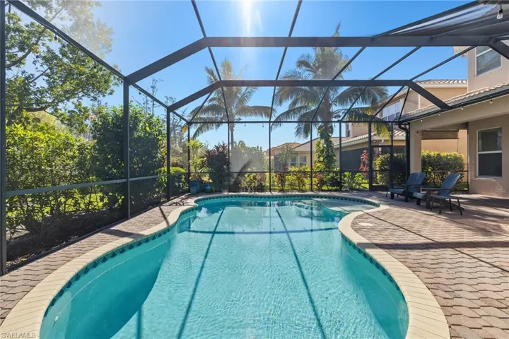 View of pool featuring a patio area and screened enclosure