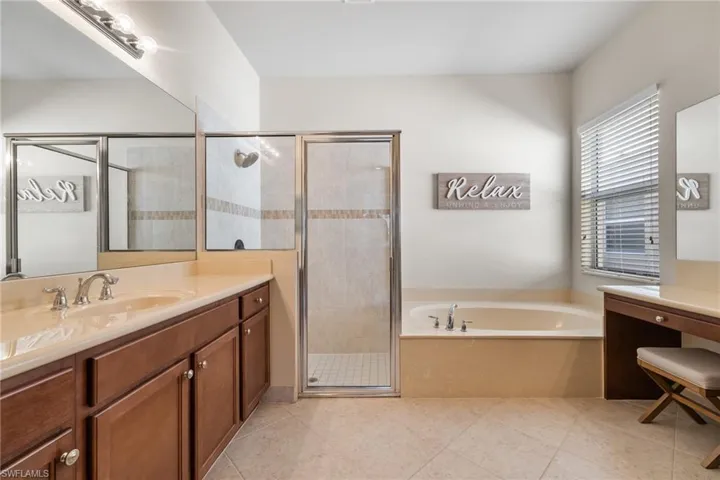 Bathroom with vanity, shower with separate bathtub, and tile patterned floors