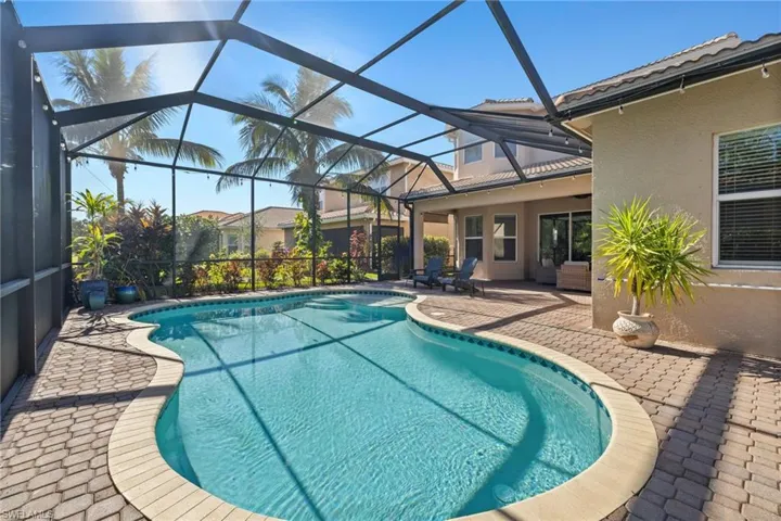 View of swimming pool featuring a patio and screened enclosure