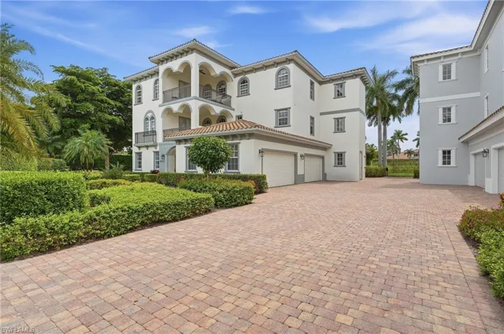Mediterranean-inspired exterior with multiple balconies, arched windows, and a tiled roof
