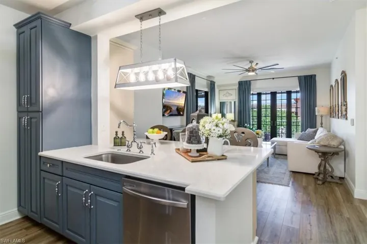 Kitchen featuring sink, ceiling fan, stainless steel dishwasher, and wood-type flooring