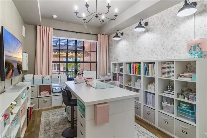 Home office with an inviting chandelier and wood-type flooring