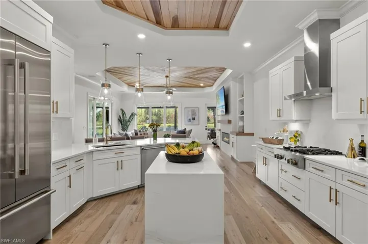 Kitchen featuring wood ceiling, a raised ceiling, light hardwood / wood-style flooring, sink, and stainless steel appliances