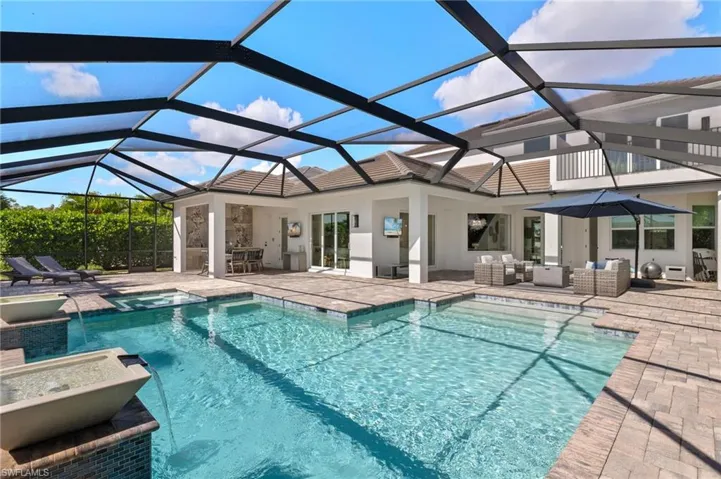 View of swimming pool featuring a patio, an in ground hot tub, glass enclosure, and an outdoor hangout area