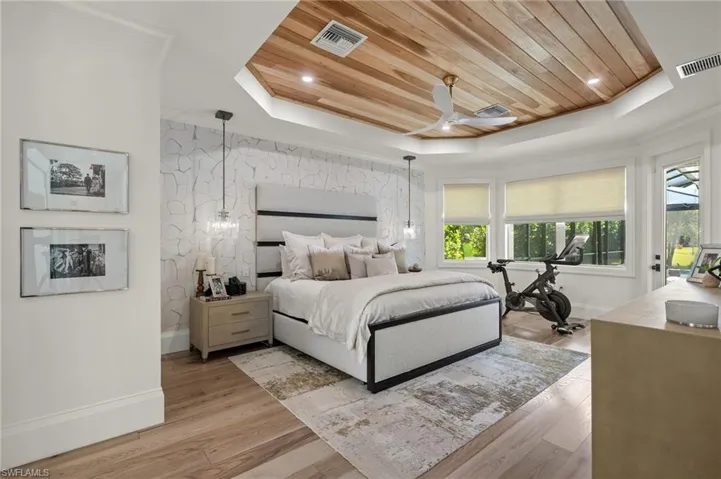 Bedroom featuring wood ceiling, ceiling fan, light wood-type flooring, and a raised ceiling