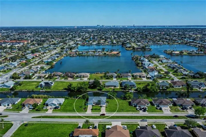 Aerial perspective of suburban area featuring a nearby body of water