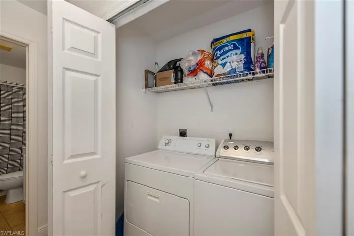 Laundry area featuring independent washer and dryer and tile patterned flooring