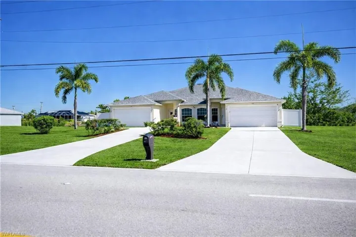 Ranch-style house featuring a front lawn, driveway, and an attached garage
