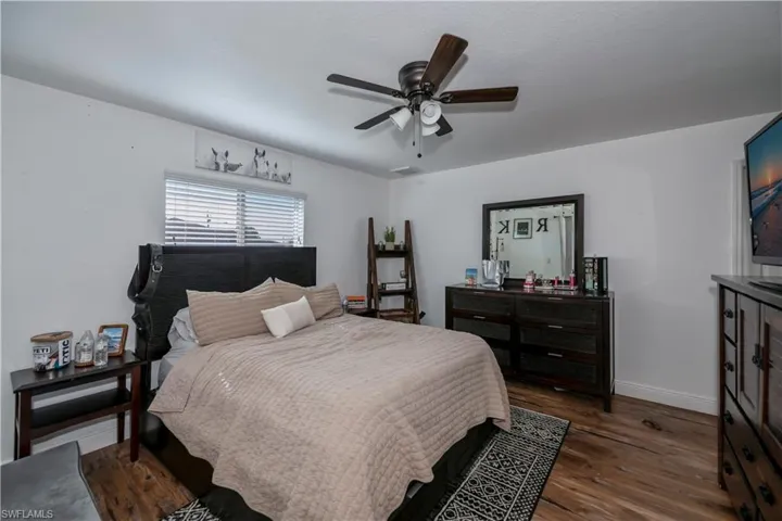 Bedroom with wood finished floors, baseboards, and ceiling fan