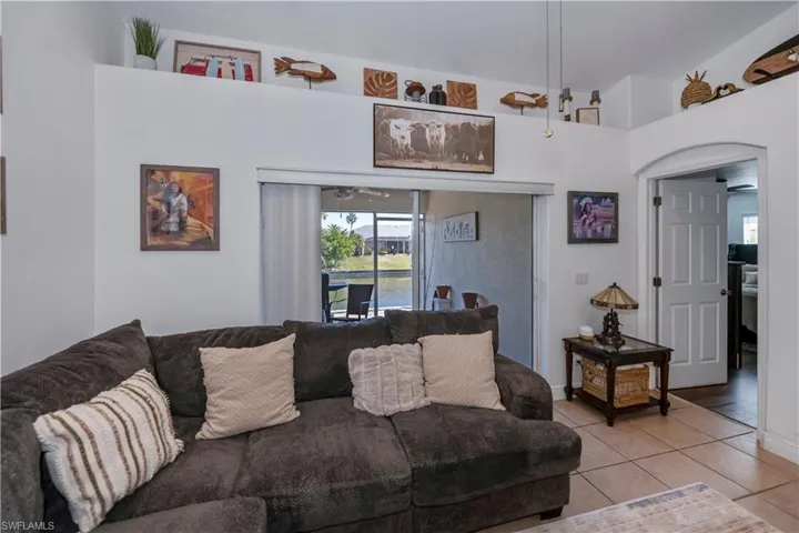Living area with light tile patterned flooring and ceiling fan