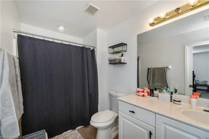 Bathroom featuring vanity, toilet, tile patterned flooring, and a shower with curtain