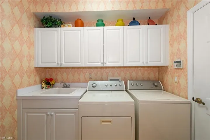 In-home laundry complete with storage cabinets!