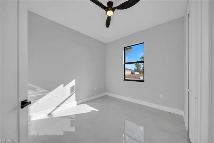 Unfurnished room with ceiling fan and finished concrete flooring