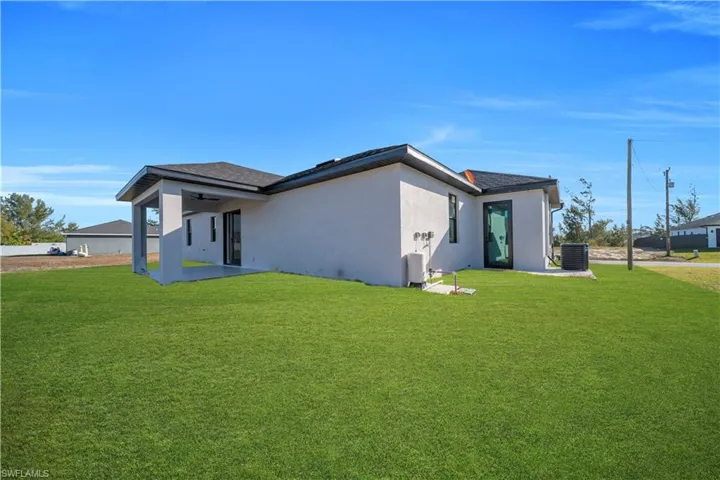 View of home's exterior with a lawn, stucco siding, a patio, ceiling fan, and a shingled roof