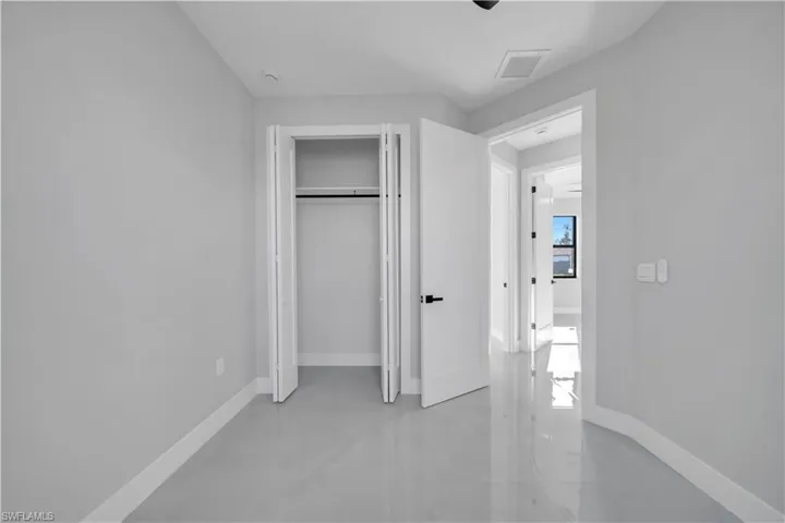 Unfurnished bedroom featuring a closet, finished concrete floors, and a ceiling fan