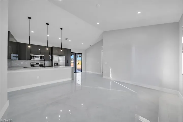 Unfurnished living room featuring lofted ceiling, french doors, and recessed lighting