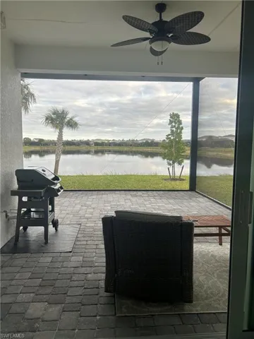 View of patio / terrace featuring area for grilling, ceiling fan, and a water view