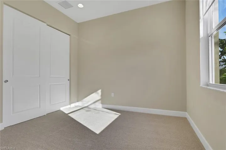 Unfurnished bedroom with carpet flooring, a closet, and recessed lighting