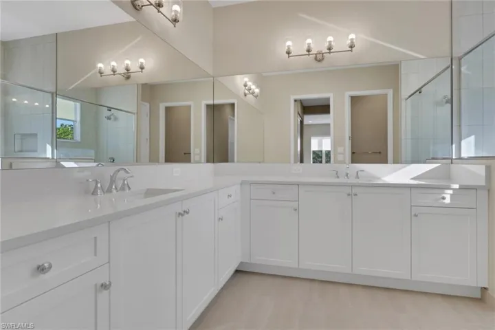Full bath featuring a stall shower and double vanity
