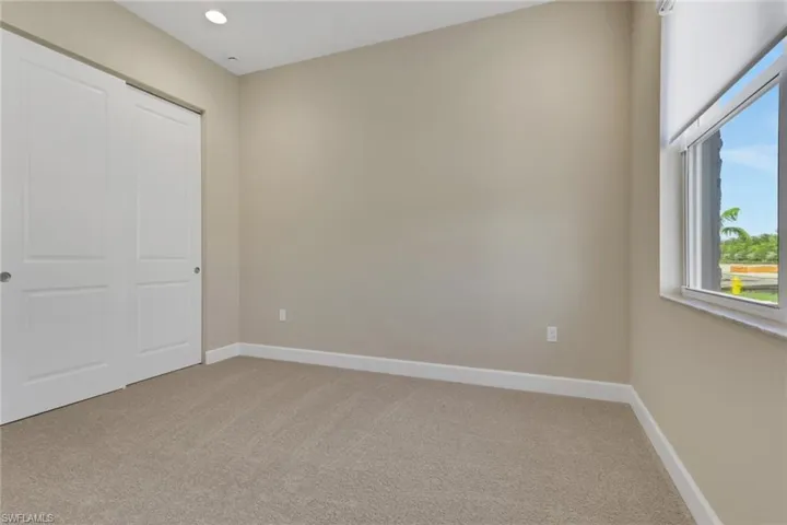 Unfurnished bedroom with light carpet, a closet, and recessed lighting