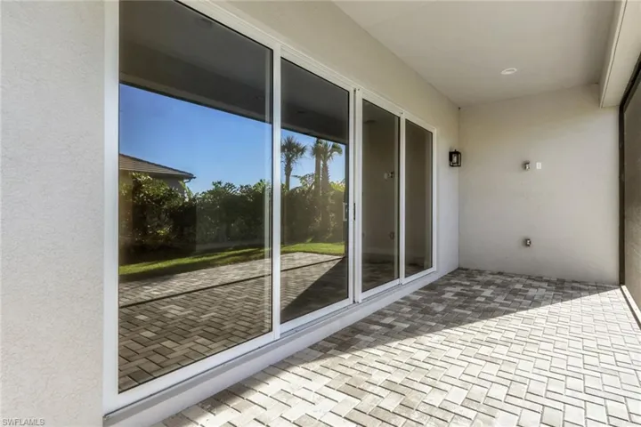 View of home from patio showcases four panel sliding doors