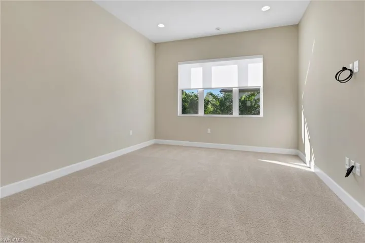 Carpeted spare room with baseboards and recessed lighting