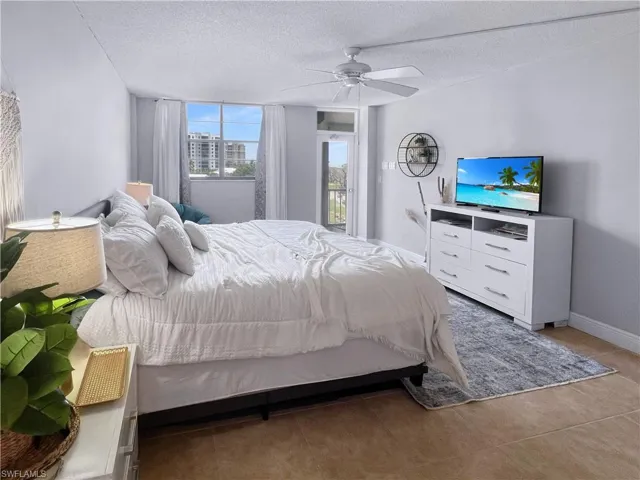 Tiled bedroom with a textured ceiling and a ceiling fan