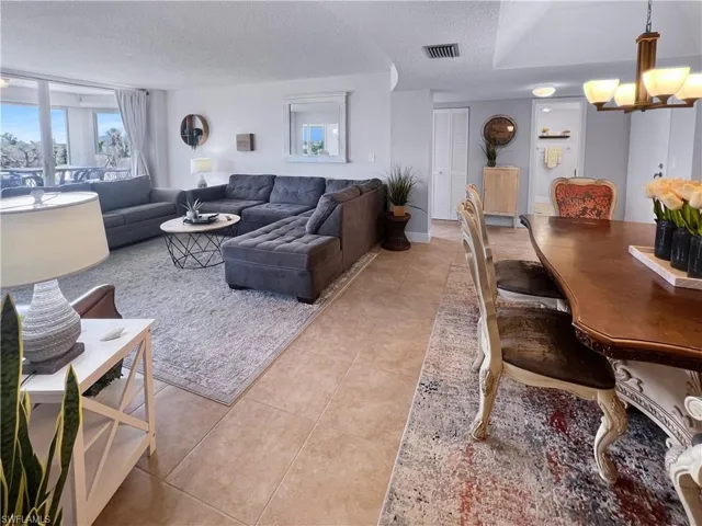 Living room featuring a textured ceiling, light tile patterned floors, and a chandelier