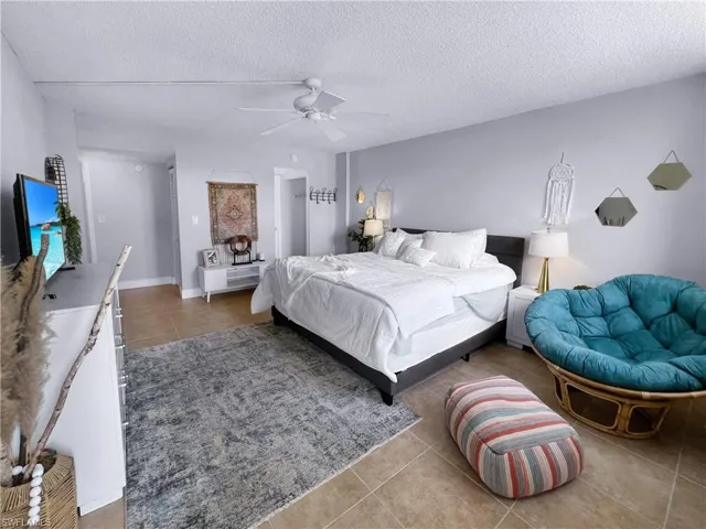 Bedroom featuring light tile patterned floors, a textured ceiling, and a ceiling fan