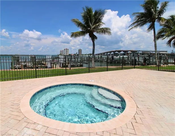 View of pool with a hot tub, a patio area, and a city view