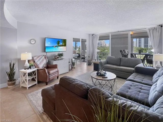 Tiled living area featuring a textured ceiling and baseboards