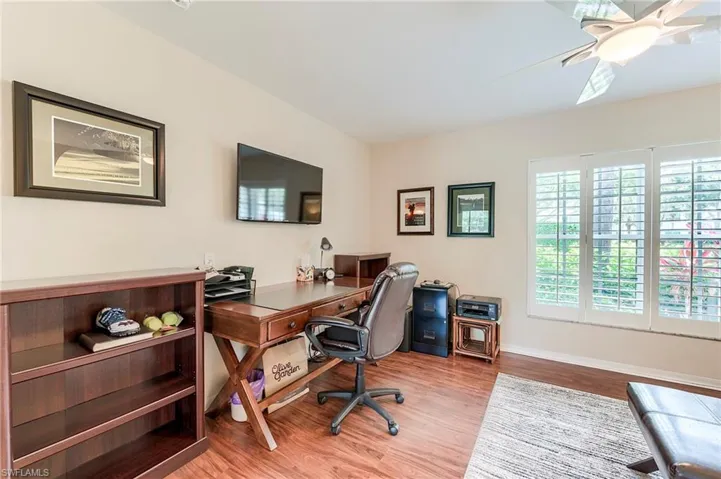 Office area with light wood-style floors, a ceiling fan, and baseboards