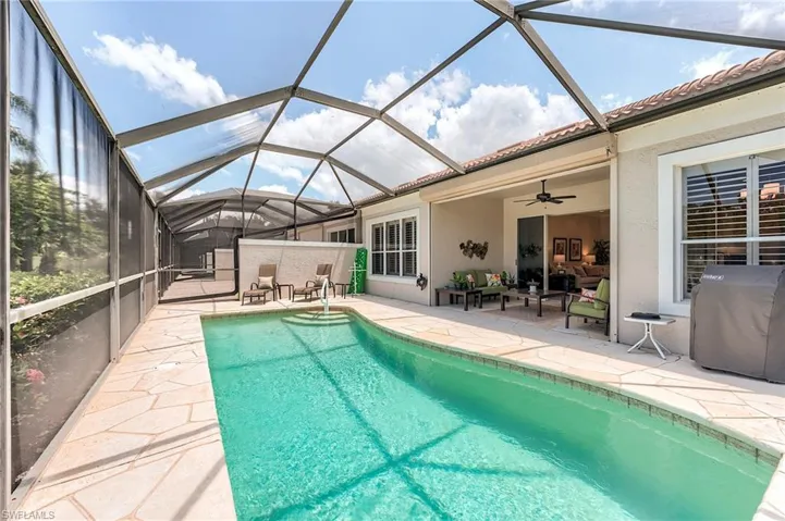 Swimming pool with a patio area, a grill, ceiling fan, and a lanai