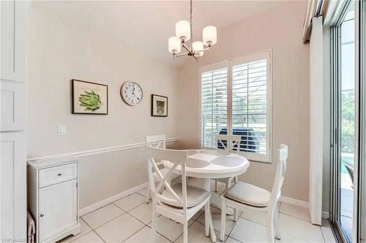 Dining room featuring healthy amount of natural light, a chandelier, baseboards, and vaulted ceiling