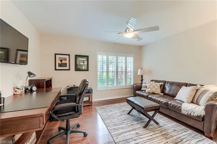 Office area with a ceiling fan, wood finished floors, and baseboards