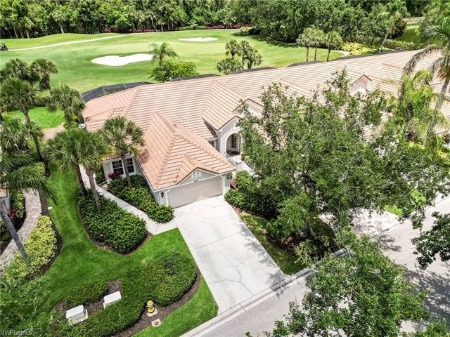View of subject property with a golf course and a tree filled landscape
