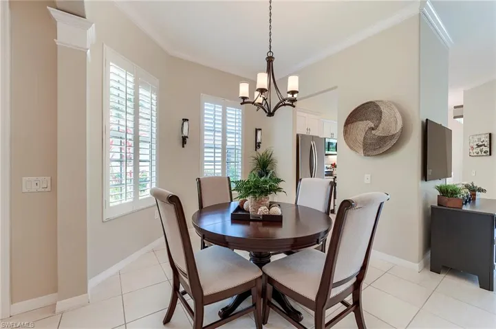 Dining room featuring healthy amount of natural light, crown molding, light tile patterned floors, and baseboards