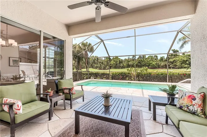 Swimming pool with an outdoor hangout area, a patio area, ceiling fan, and glass enclosure