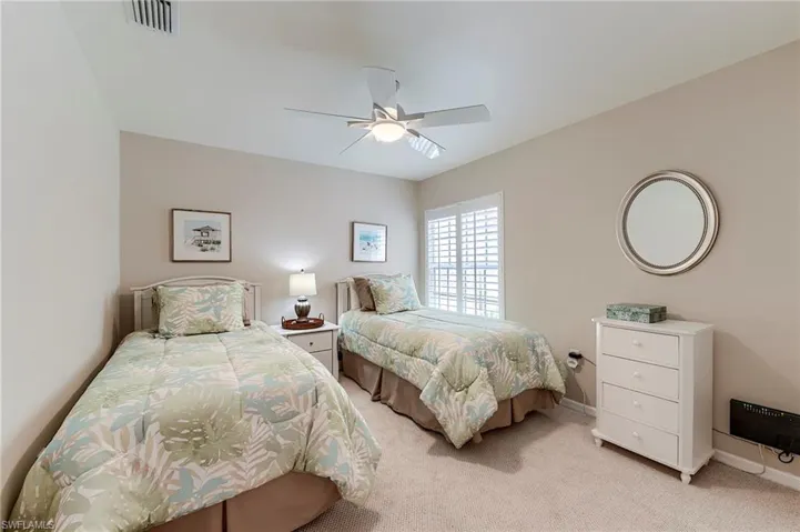 Bedroom featuring light colored carpet, baseboards, and ceiling fan