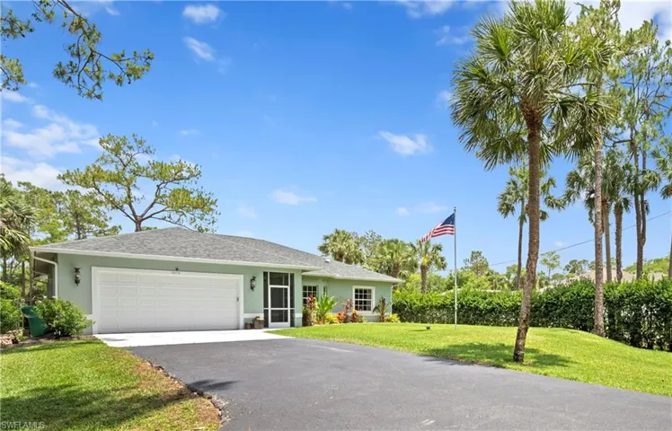 Ranch-style home featuring a front lawn, a garage, stucco siding, asphalt driveway, and a shingled roof