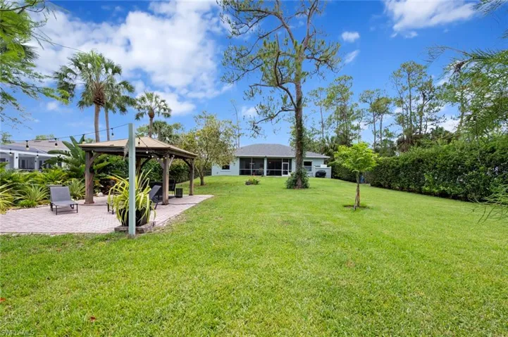 View of grassy yard with a gazebo and a patio