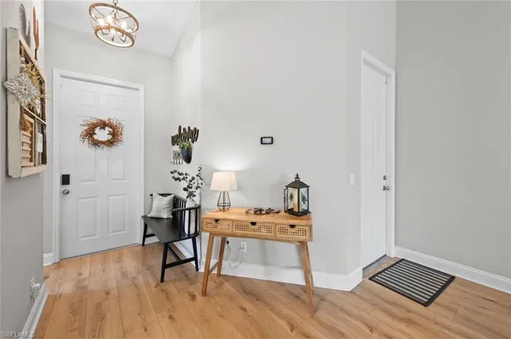 Entryway with light wood-style flooring and a chandelier