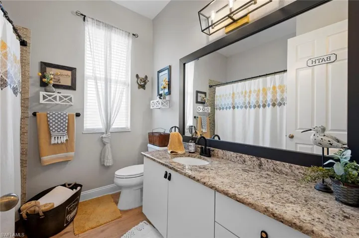 Bathroom featuring vanity, curtained shower, and light wood finished floors