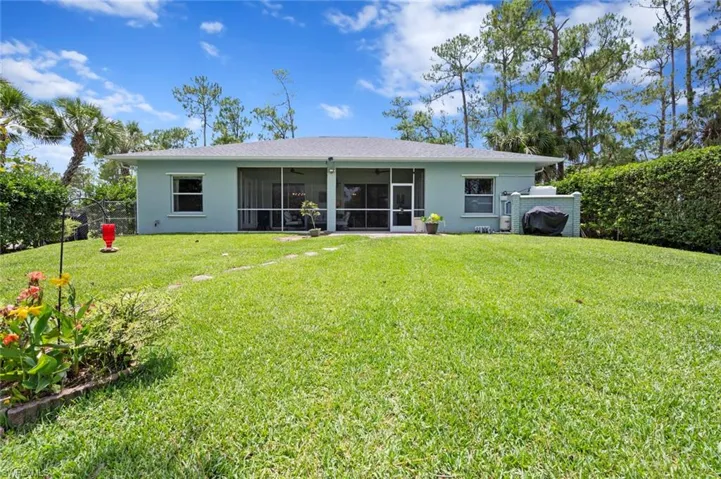 Rear view of property with a sunroom, a ceiling fan, and stucco siding