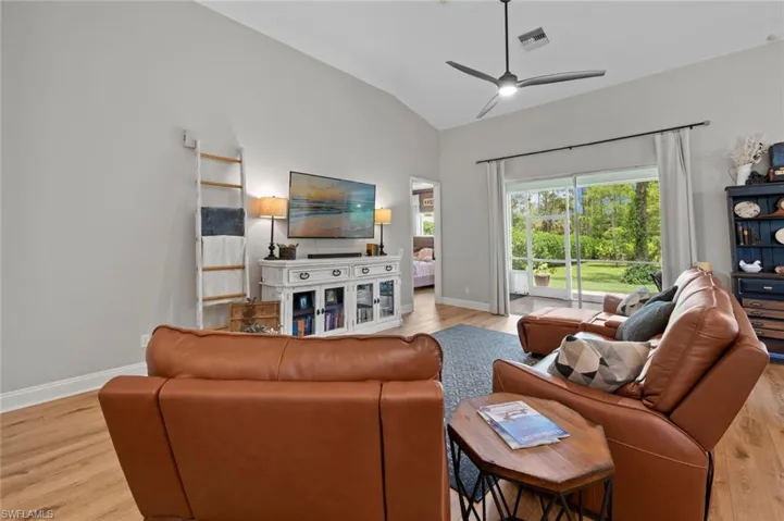 Living area with light wood finished floors, vaulted ceiling, and ceiling fan