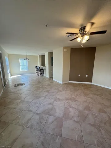 Unfurnished room with a chandelier and ceiling fan