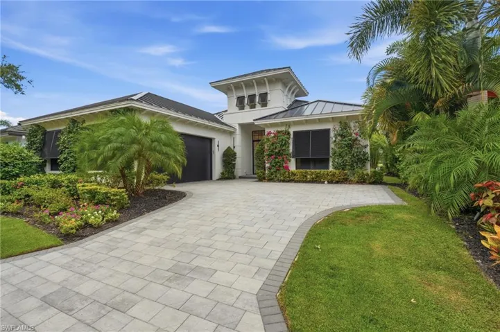 Contemporary exterior featuring white stucco, a dark shingle roof, and a prominent central cupola