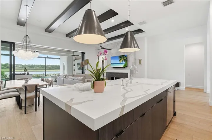 Kitchen island featuring a veined countertop and integrated sink